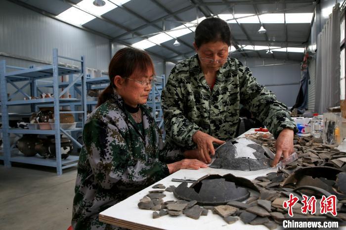 考古人员正在整理陶器碎片 杨东 摄